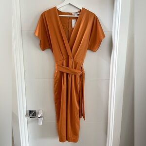 Burnt orange, short sleeved dress with front slit and pockets.